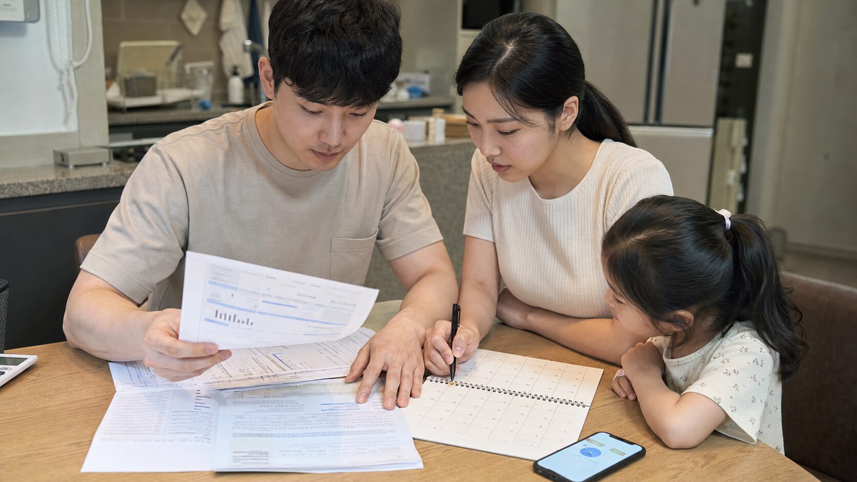가족이 전기요금 고지서와 달력을 보며 에너지캐시백 신청 시점을 확인하는 장면